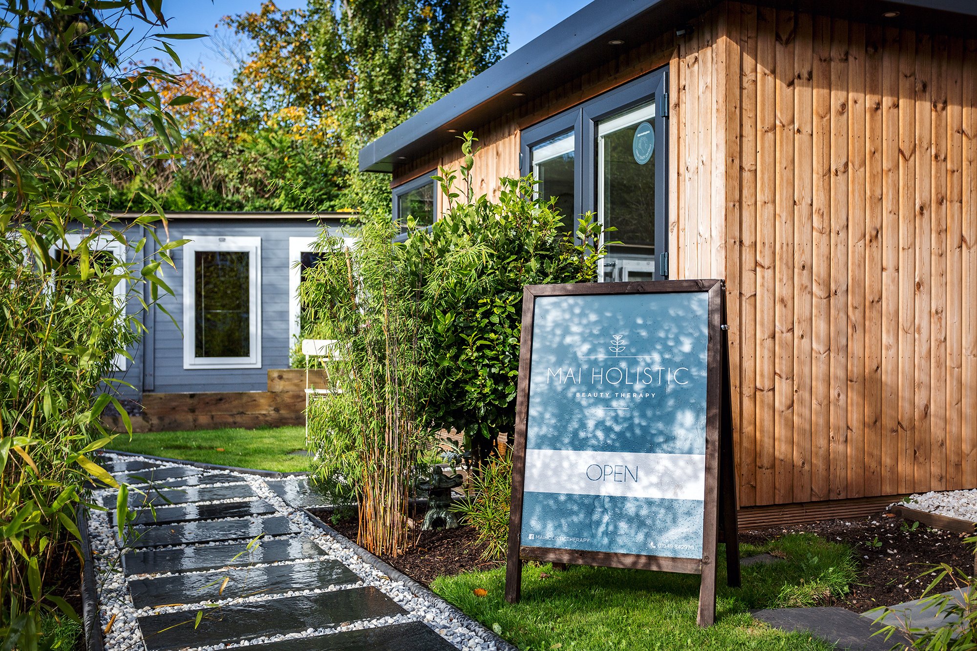 Outside shot of a garden home beauty studio in redwood with A board outside