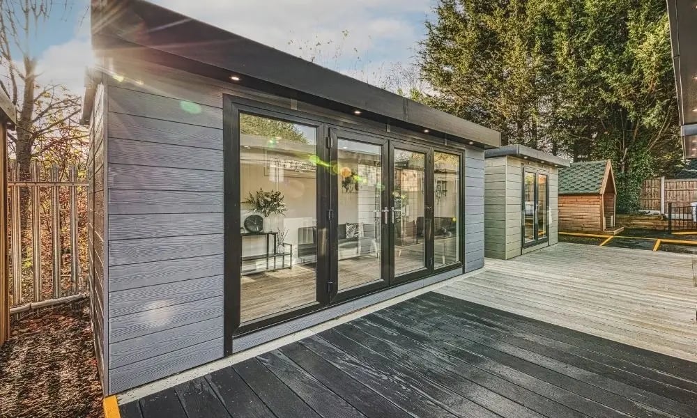 Low-maintenance garden room with Marley board cladding, large glass doors and timber decking, designed for year-round use as a modern outdoor living space.