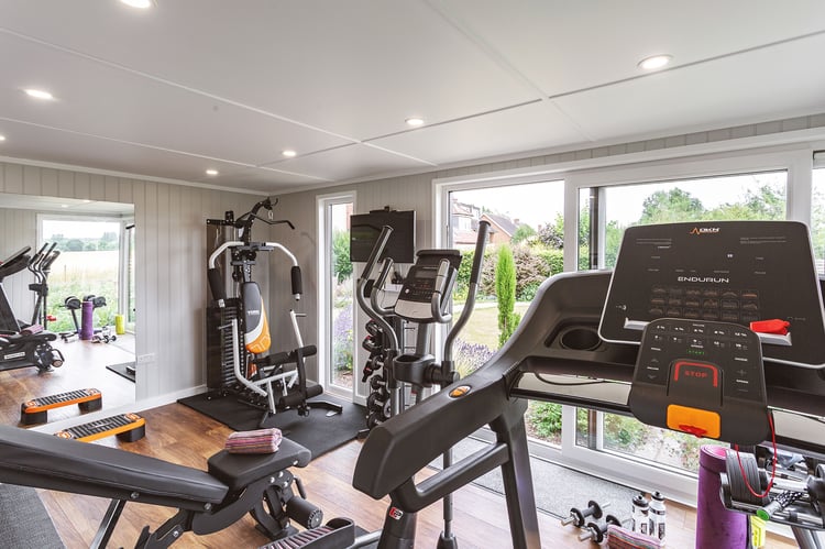 Interior of a fully equipped Gym Garden Room with cross trainer, bikes and other fitness equipment