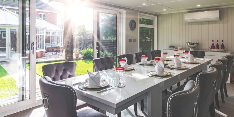 Interior of a garden dining room set out with premium cutlery and crockery ready for a dinner party