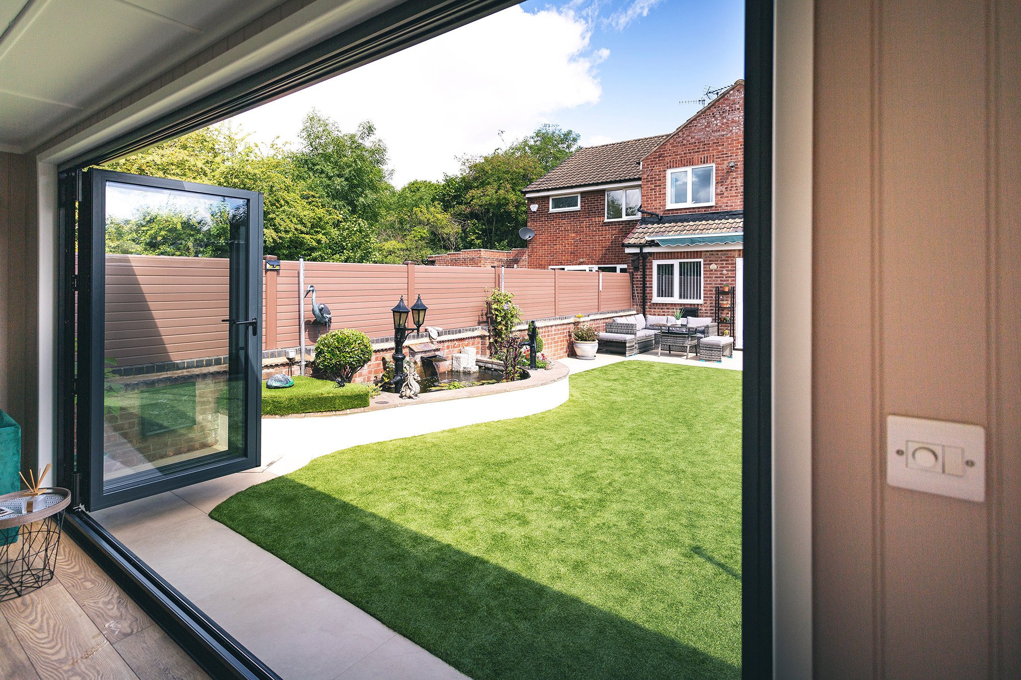 Looking outside from  the bi-fold doors inside a zero maintenance garden room office