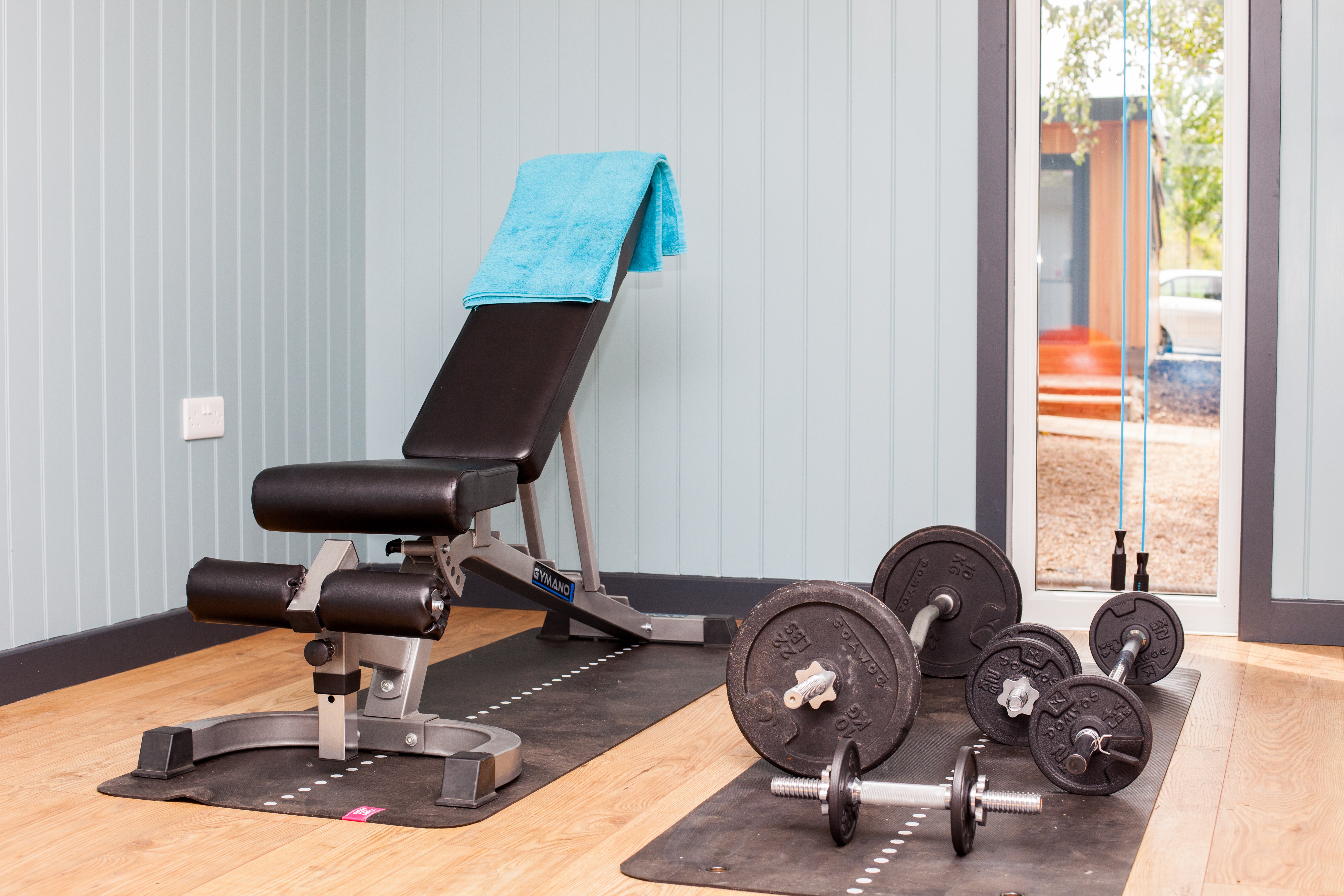 Interior of a garden room gym with fitness equipment setup ready for a workout