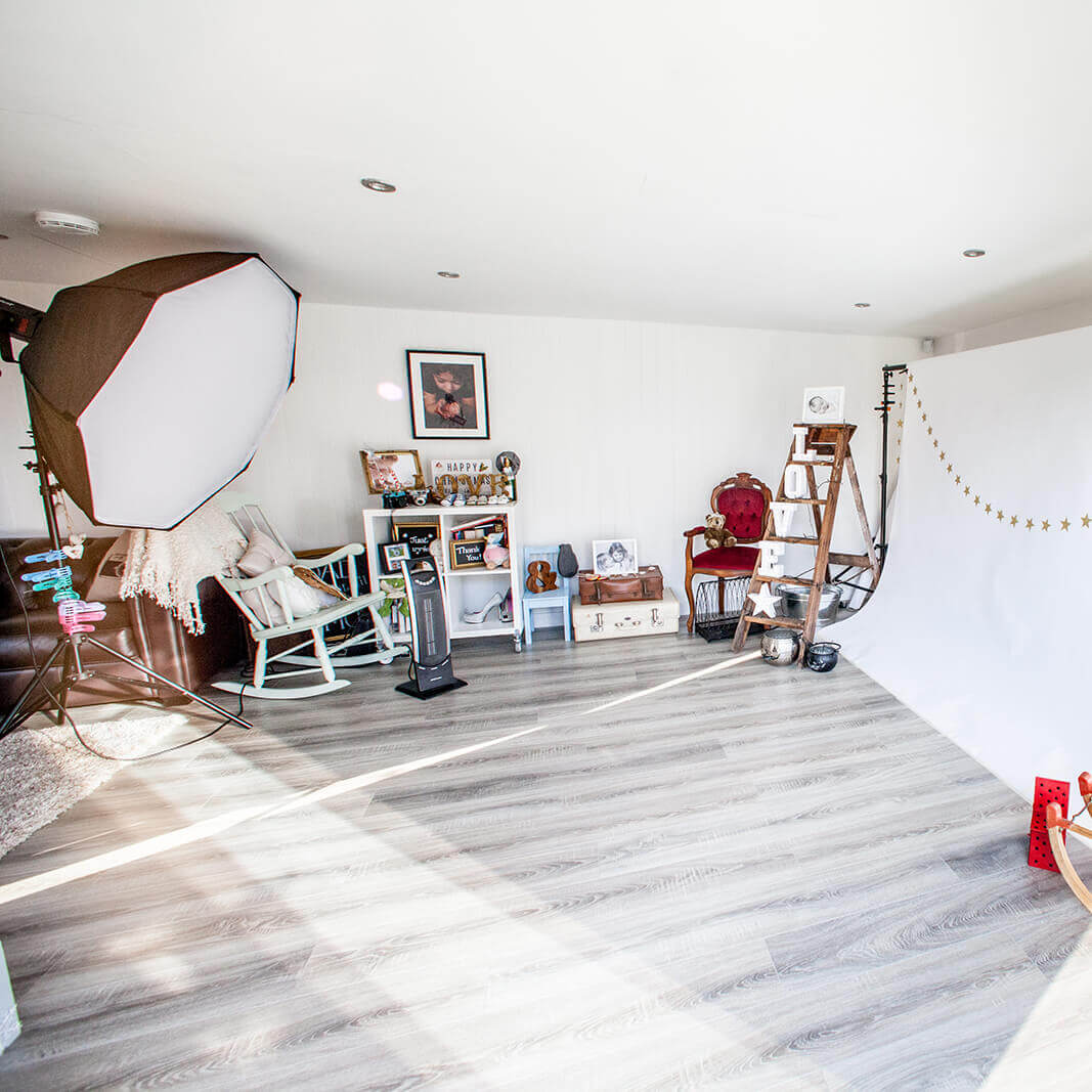 Internal shot of a garden room photo studio with backdrop, lighting, decor and props