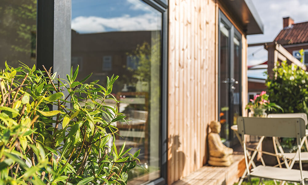 Outside a garden room beauty studio with stone sculpture outside