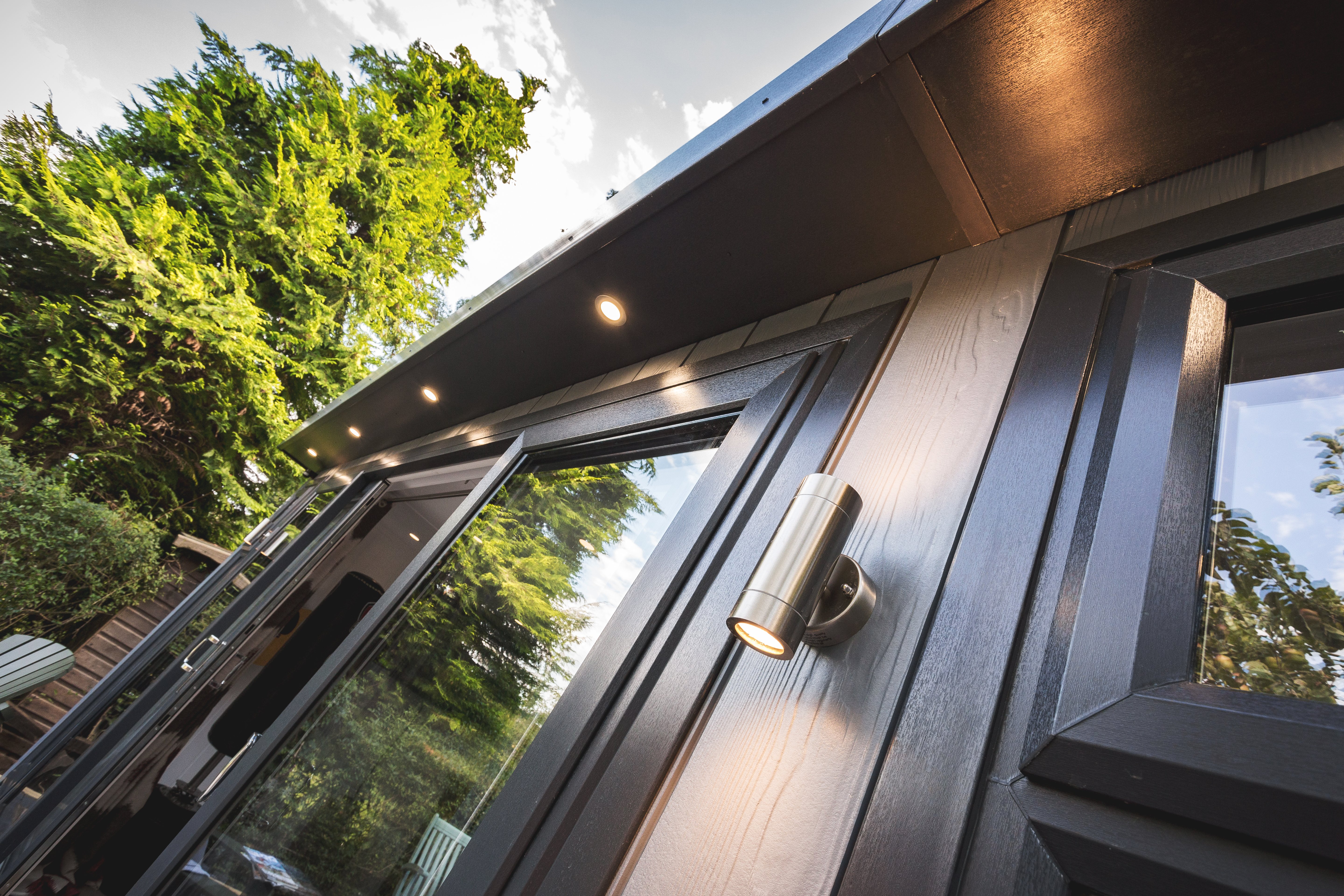 Close up of a zero maintenance garden room with black windows and doors