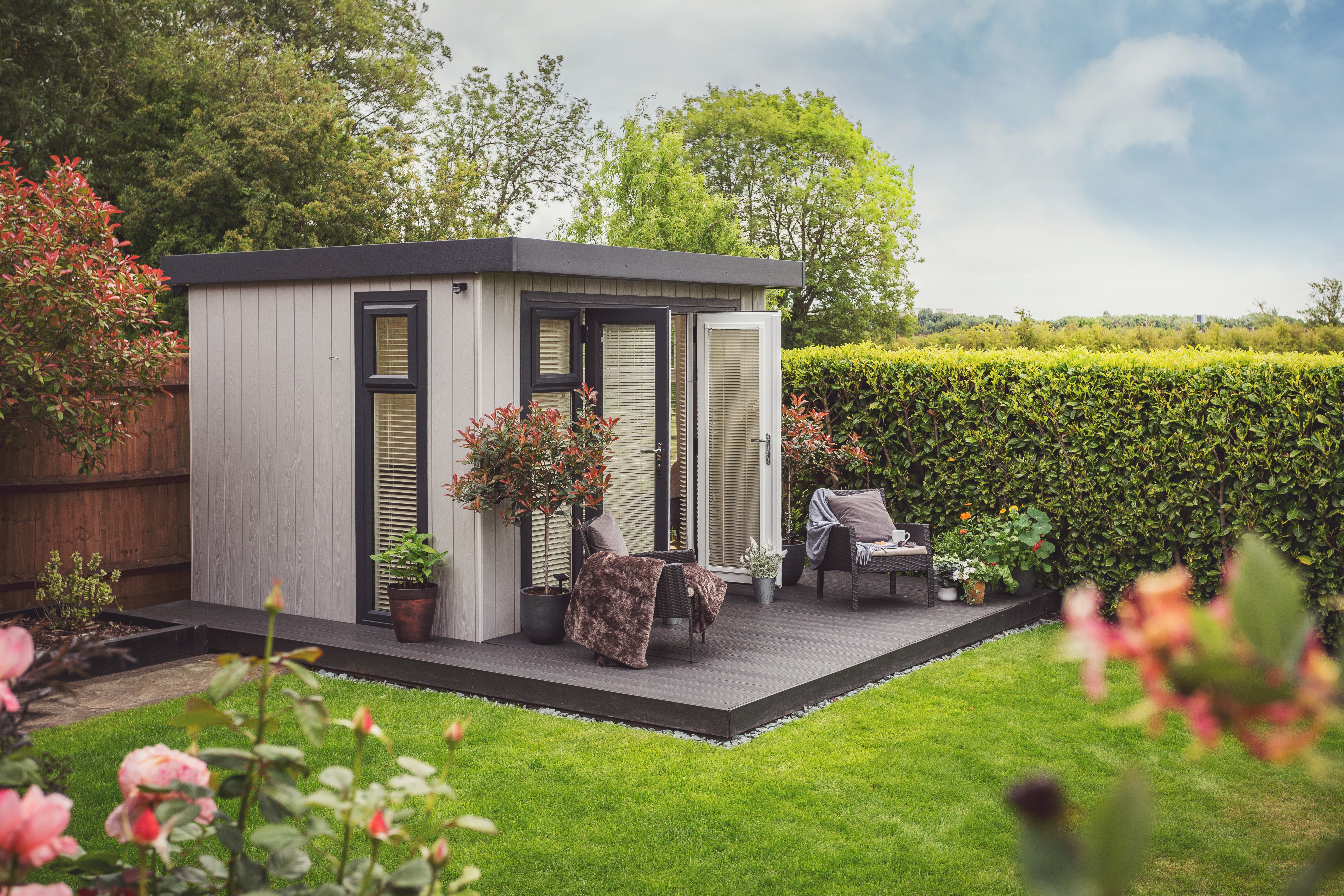 Small zero maintenance garden room on decked area with french doors open