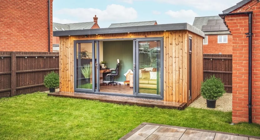 Modern garden room in a backyard, styled as a study space with a desk, office chair, and sofa – ideal for kids needing a quiet, dedicated area for schoolwork and revision