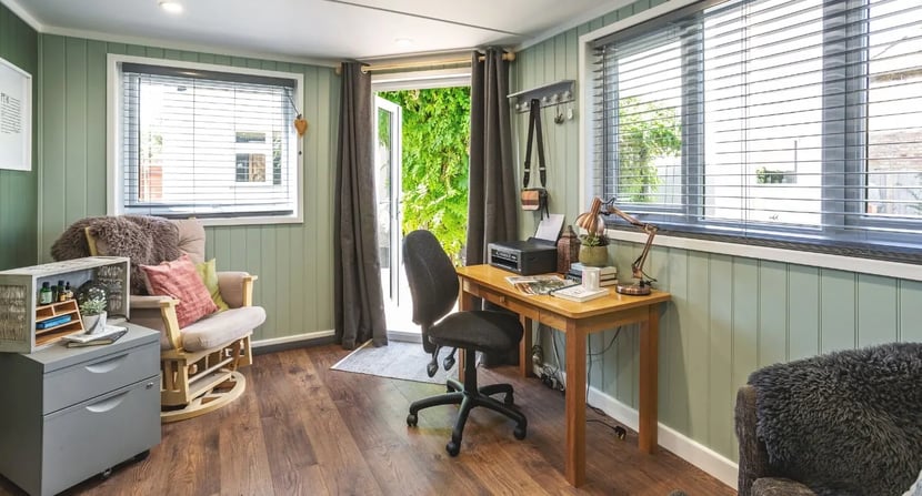 Cosy garden room interior with a wooden desk, office chair, and natural light—designed as a quiet, focused study space for kids and teens during exam season