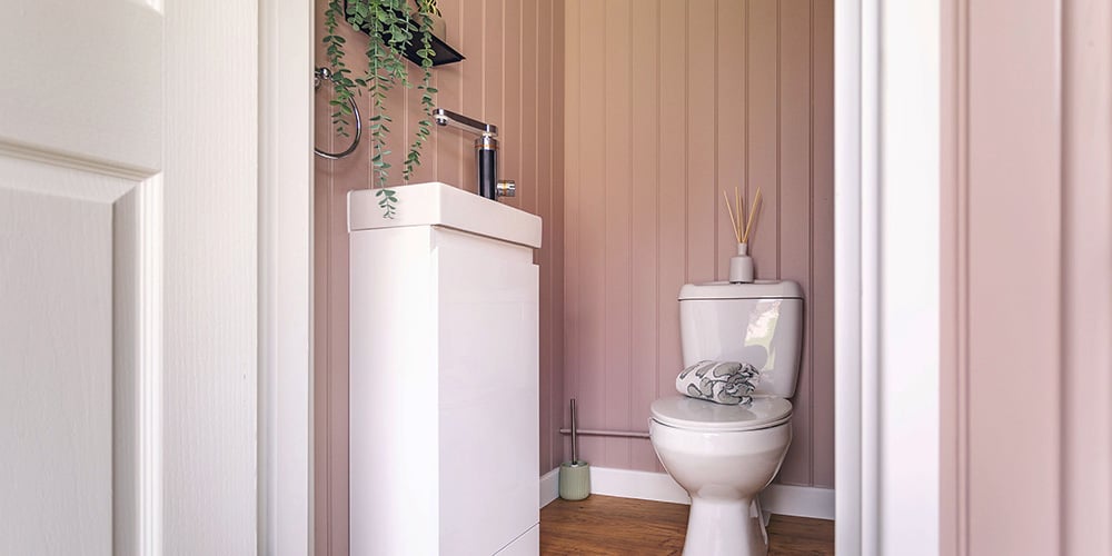 Interior of washroom installed in a garden room, with toilet & sink