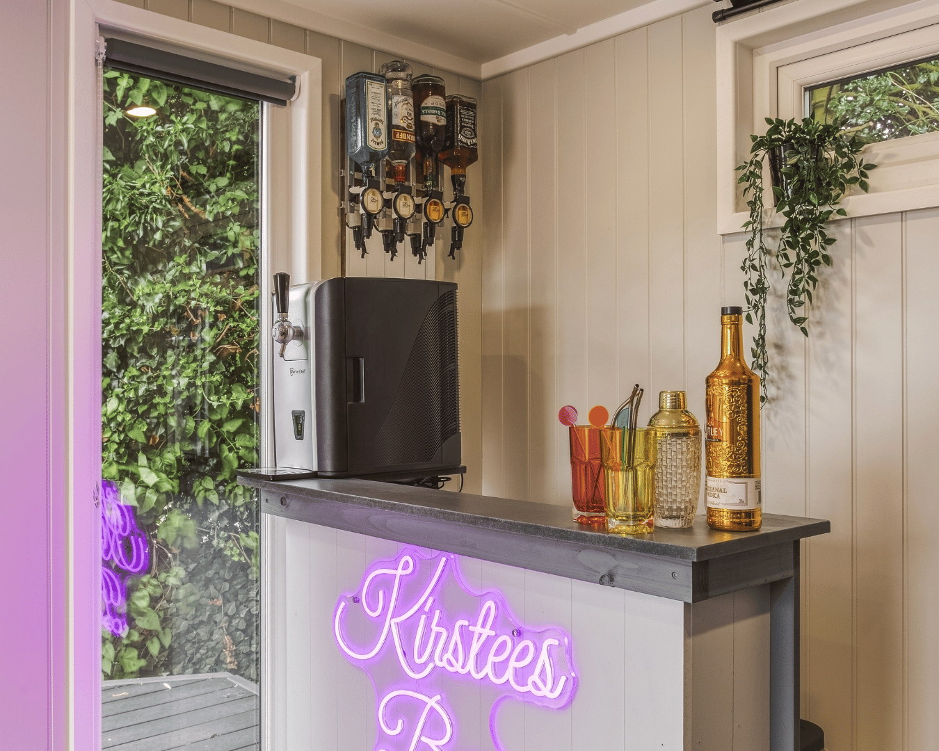 garden bar with custom LED sign and bottles displayed