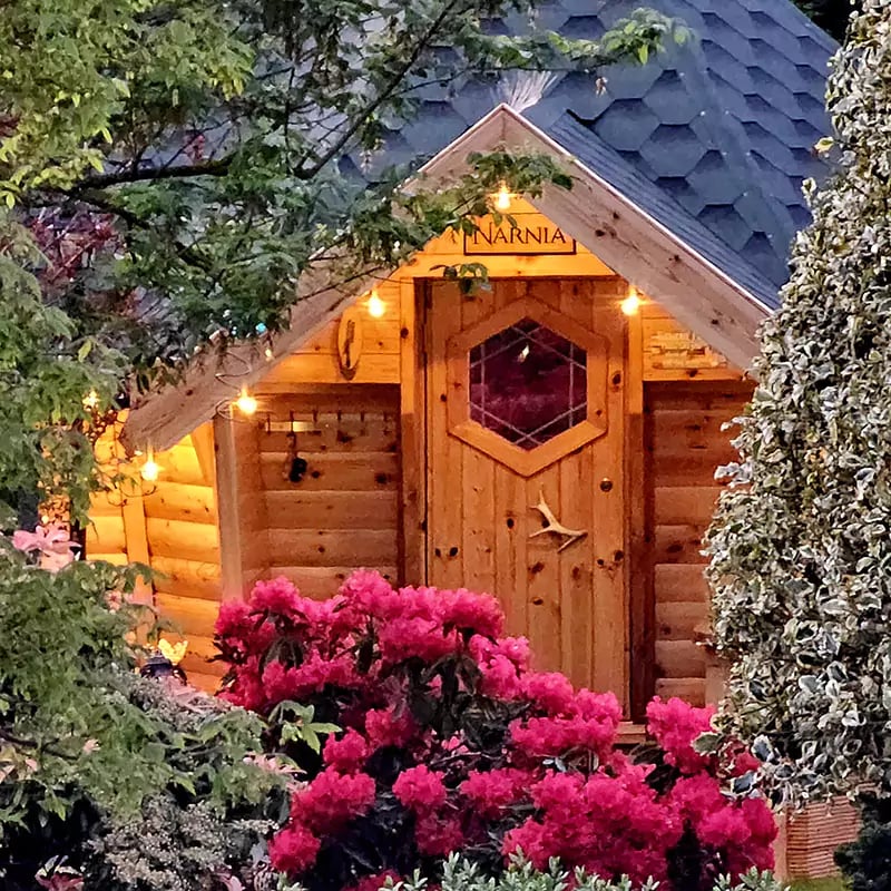 Hobbit house grill hut on stoney decked area with trees surrounding