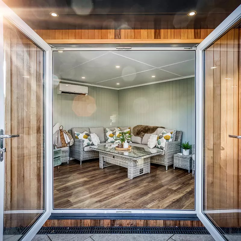 looking inside a small garden room through open french doors