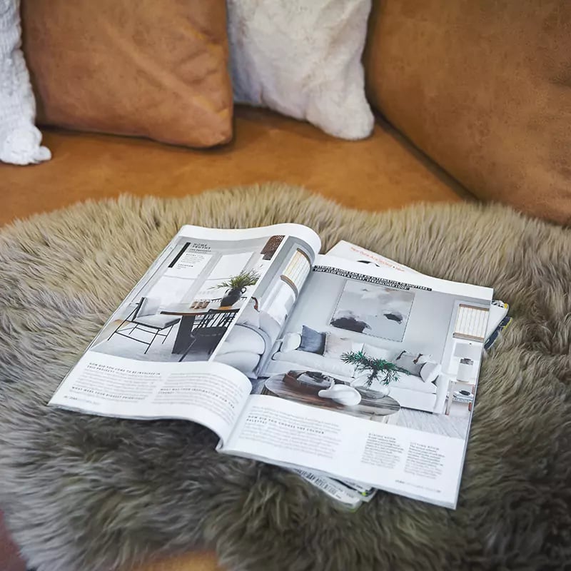 Magazine open at Cabin Master advert on sofa