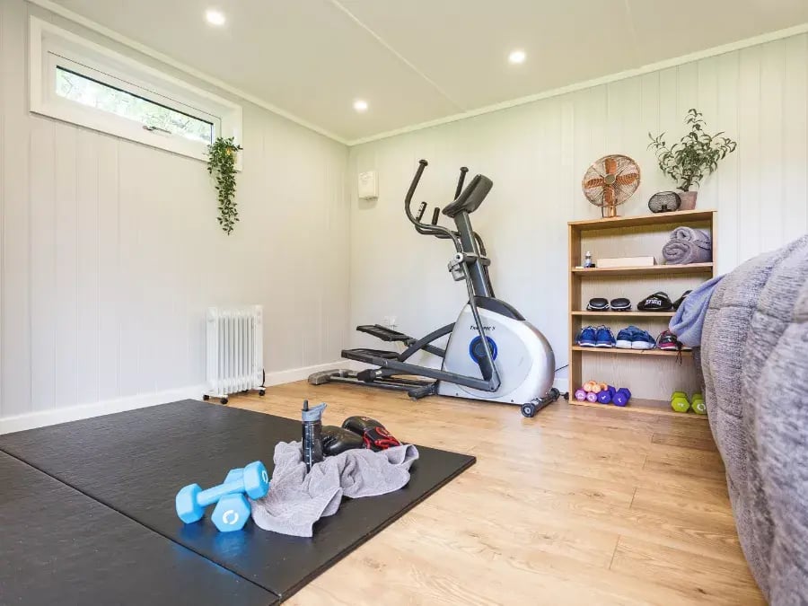 inside garden gym with mat, exercise bike & weights