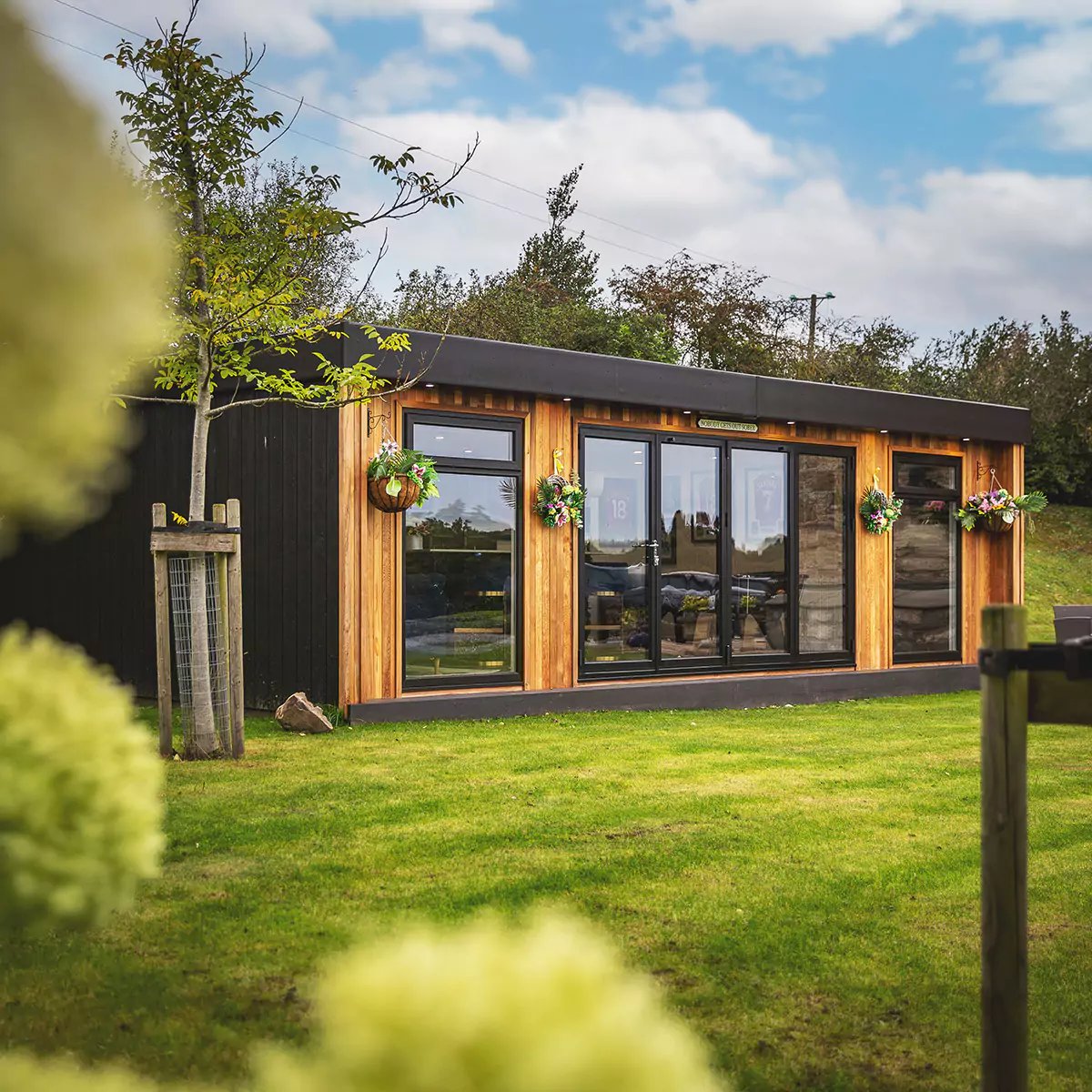 Looking inside a large luxury garden bar with bifold doors