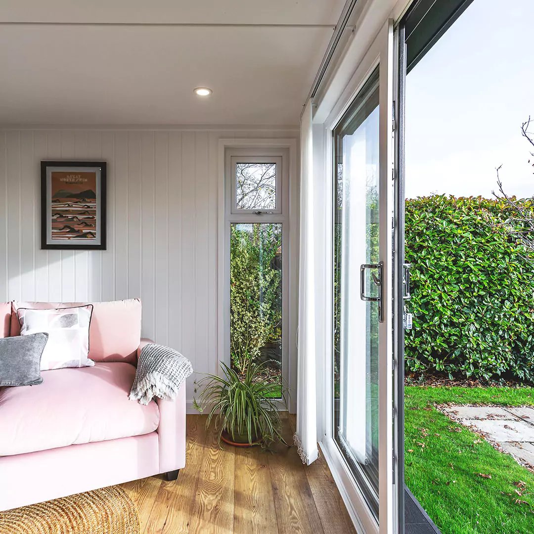 Interior of a garden office with blush pink velvet sofa