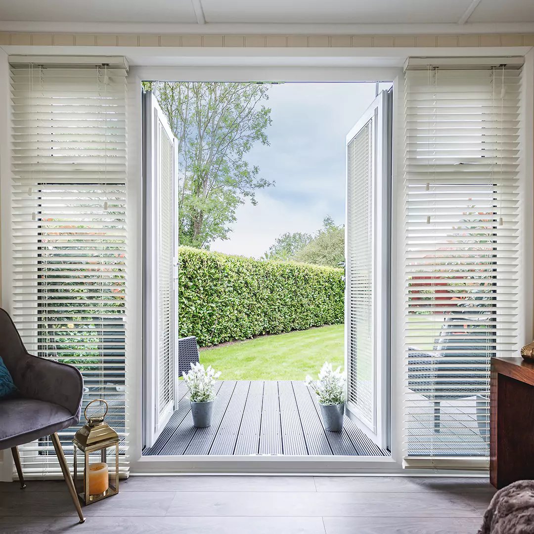 Summerhouse with Indoor Furnishings and view of lawn area with timber decking and open door