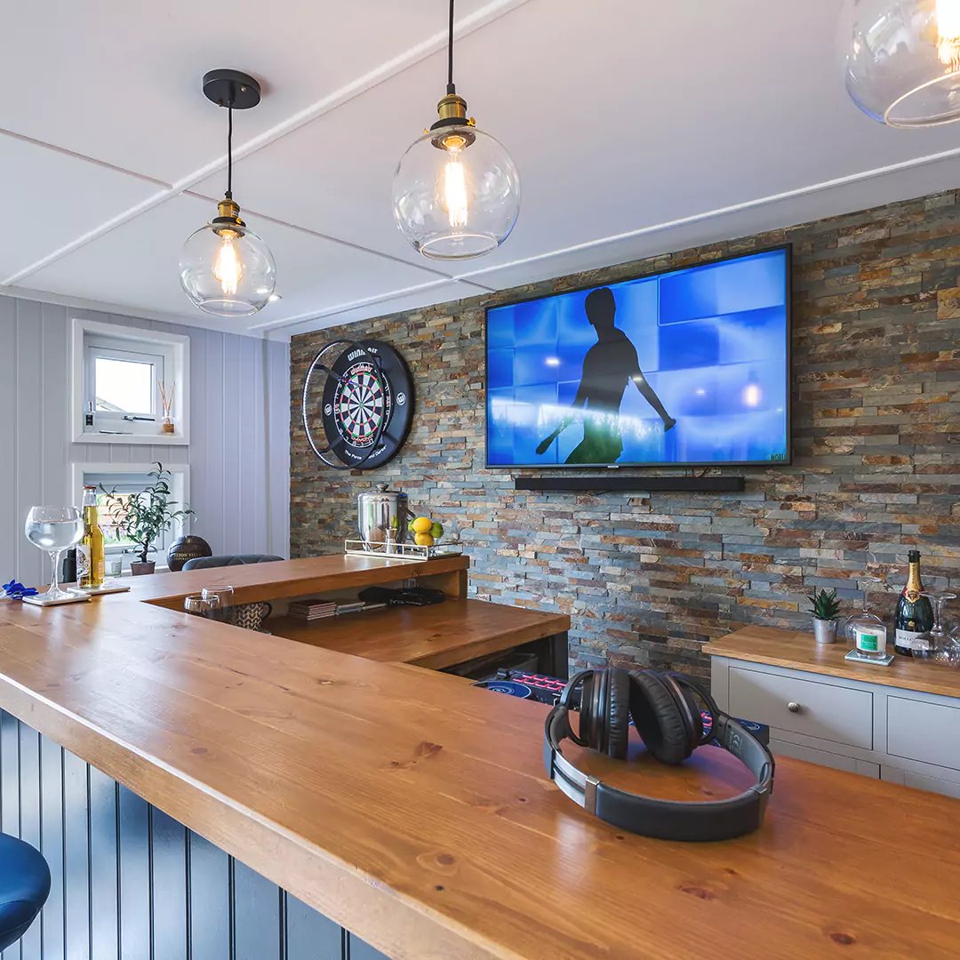interior of a garden bar with pendant lights & dart board