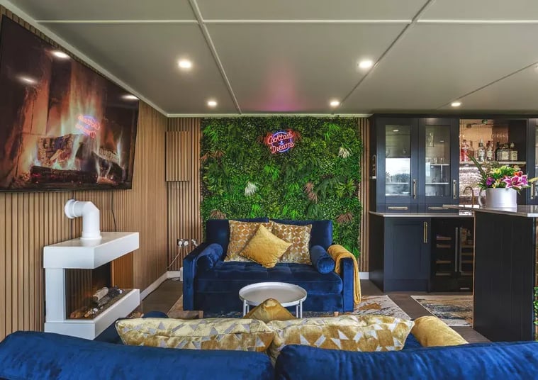 inside a man cave with a log burner and neon light