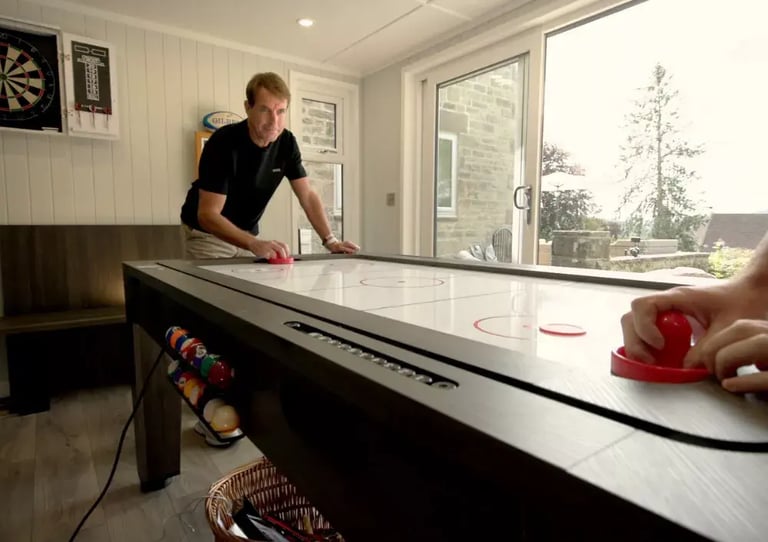 inside a garden man cave with man playing air hockey