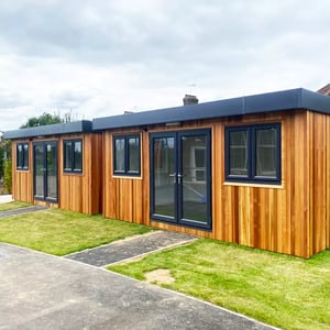 School cabin building on playground next to traditional school building