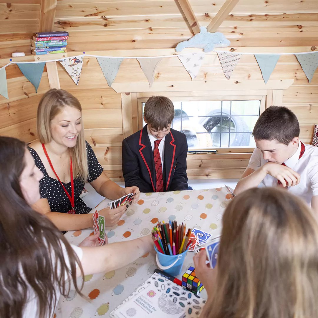 children with teacher inside an outdoor classroom cabin