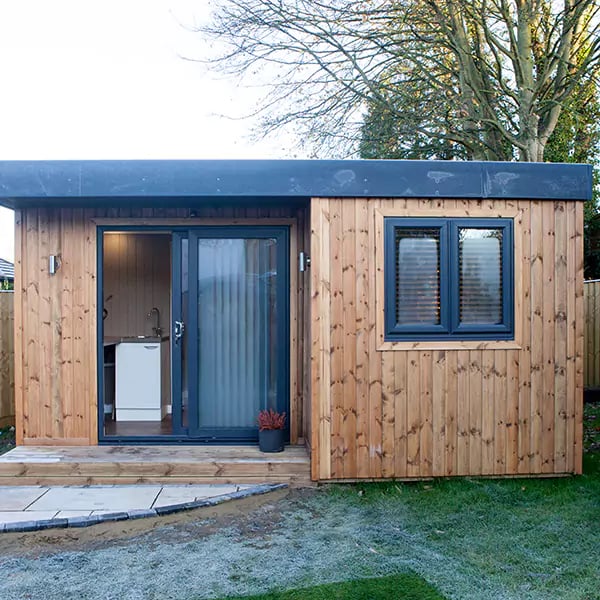 redwood garden room home spa in grassy lawn area with timber step on patio area