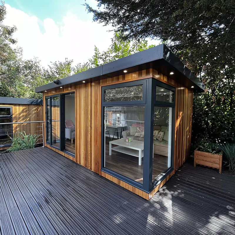 large cedar garden room on nottingham show site with timber decking and planter next to it