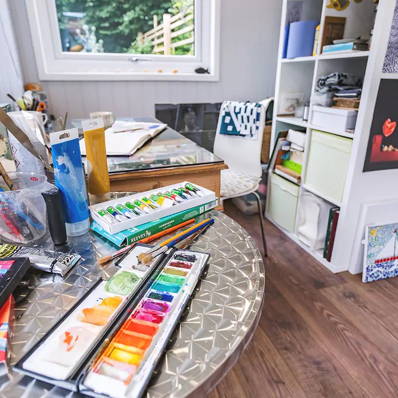 inside view of cabin master garden room with laminate flooring and drawings and easel and storage unit with art and craft accessories