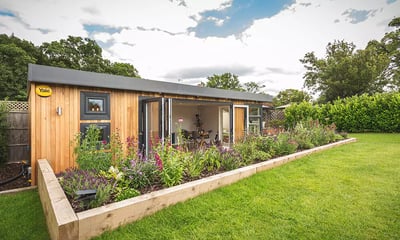 large garden man cave with raised planter in foreground