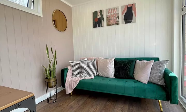 Interior of a garden room office with dusky pink and bottle green decor