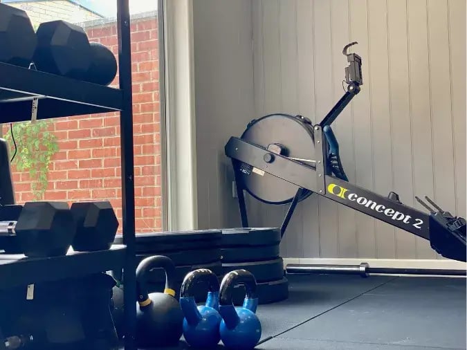 garden gym interior with rowing machine and weights