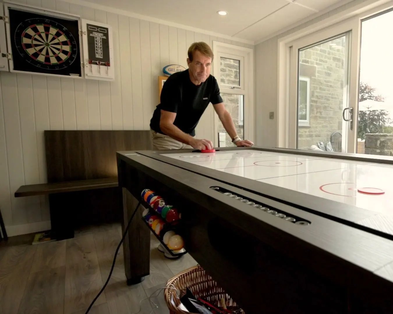 man playing air hockey inside a garden games room