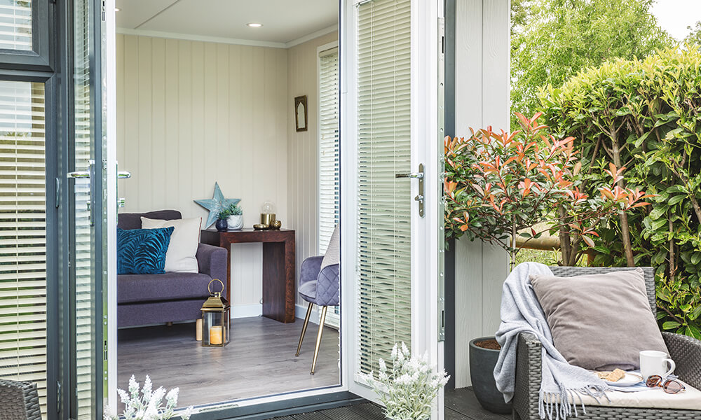 Looking inside a garden room snug with open french doors