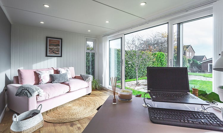 Interior of a garden office with desk and laptop