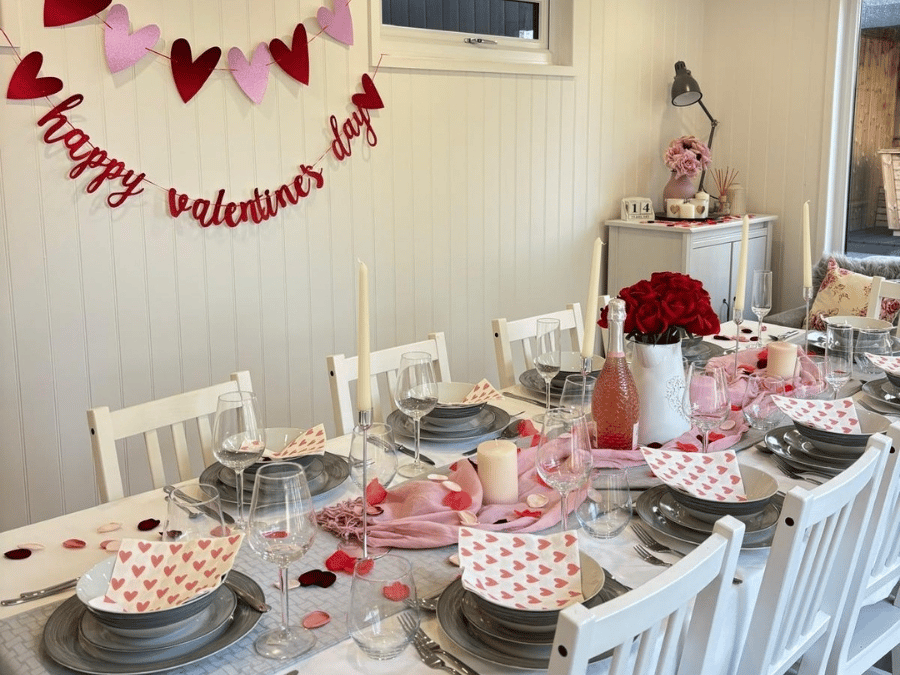 Garden room dining area decorated for Valentine’s Day with a pink and red table setting.
