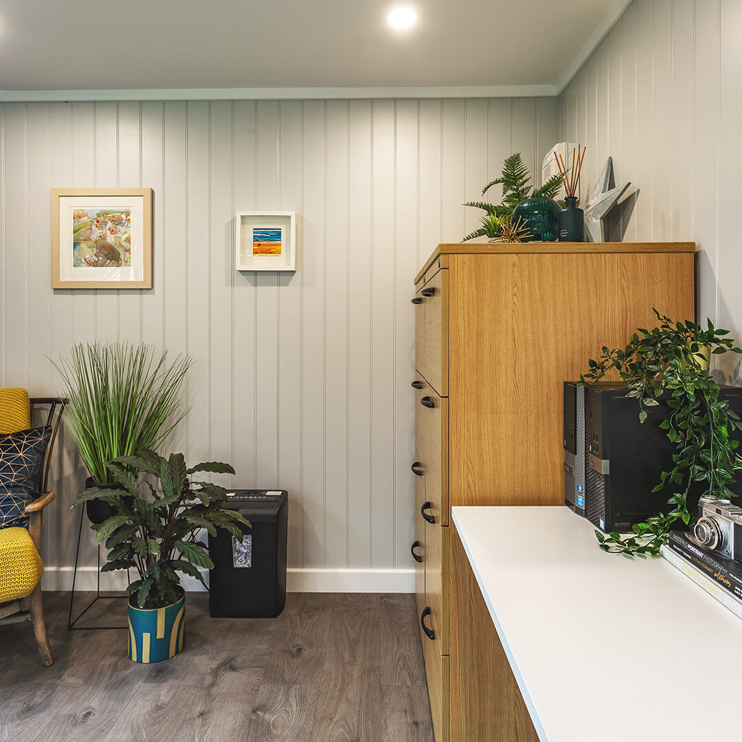 redwood garden home office with desk and chest of drawers and indoor plants with wall hangings and home furnishings