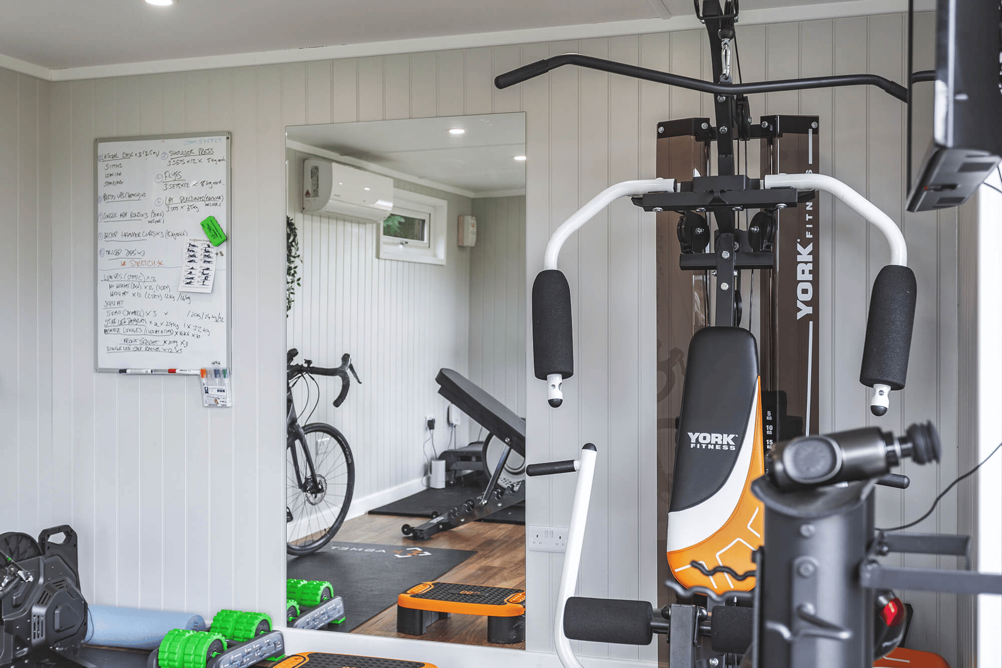 Interior of a gym in the garden with mirror and exercise equipment