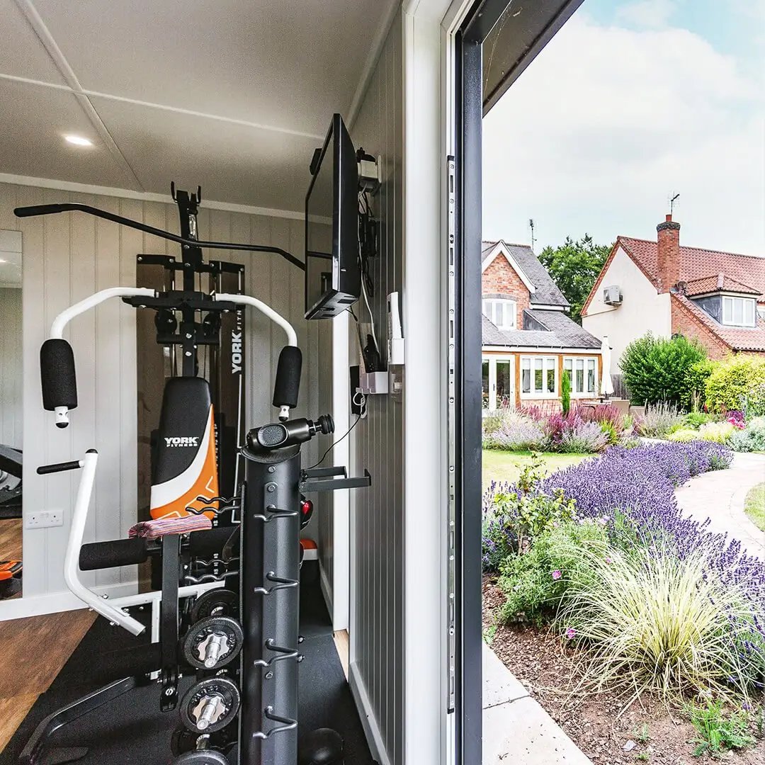 Interior of a gym in the garden with mirror and exercise equipment