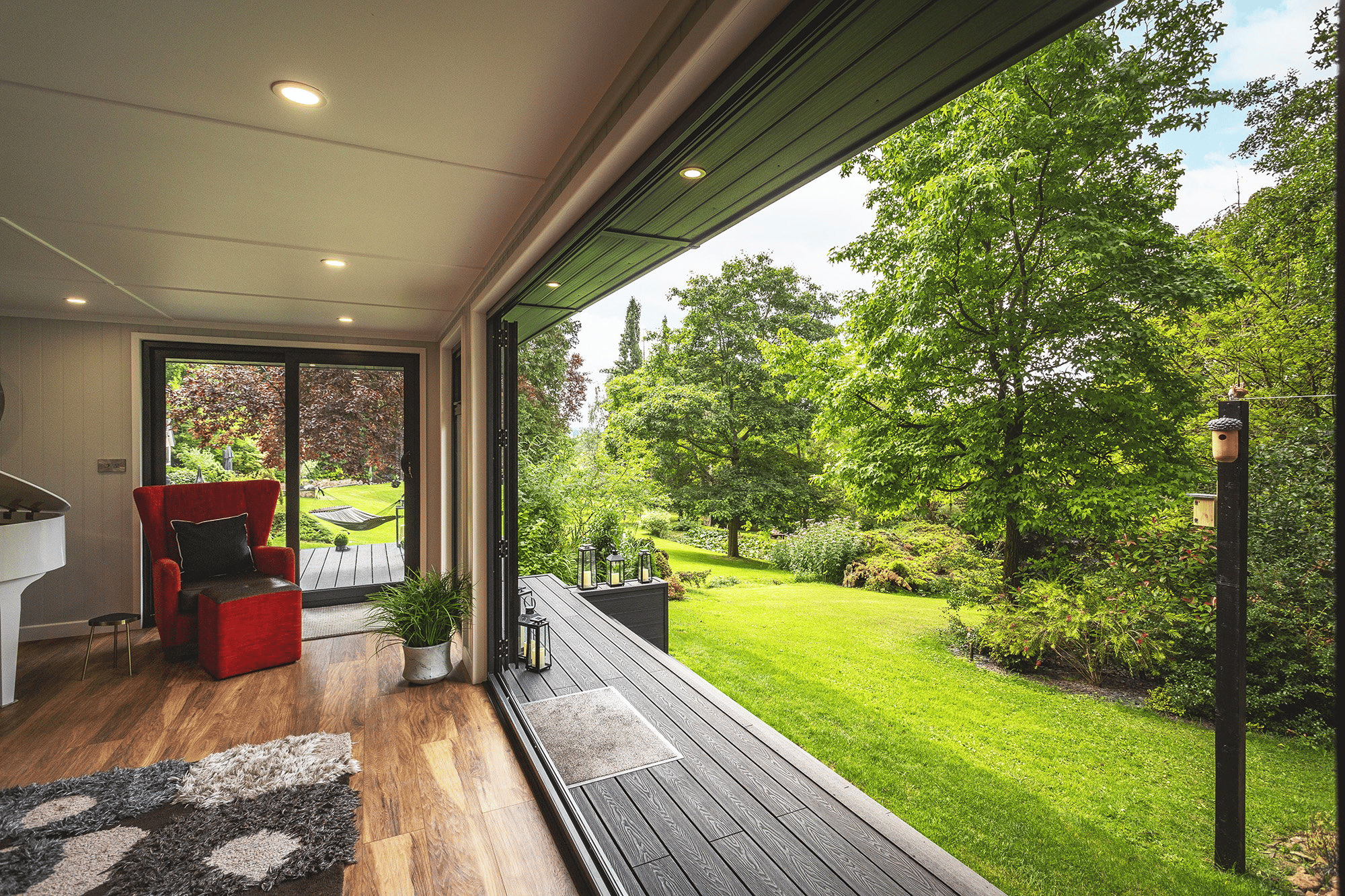 Large Garden Veranda Room with open bifold doors onto lawn area 
