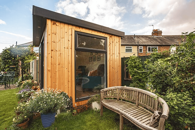 redwood garden room with brown bench and grassy area and outdoor plants and foliage