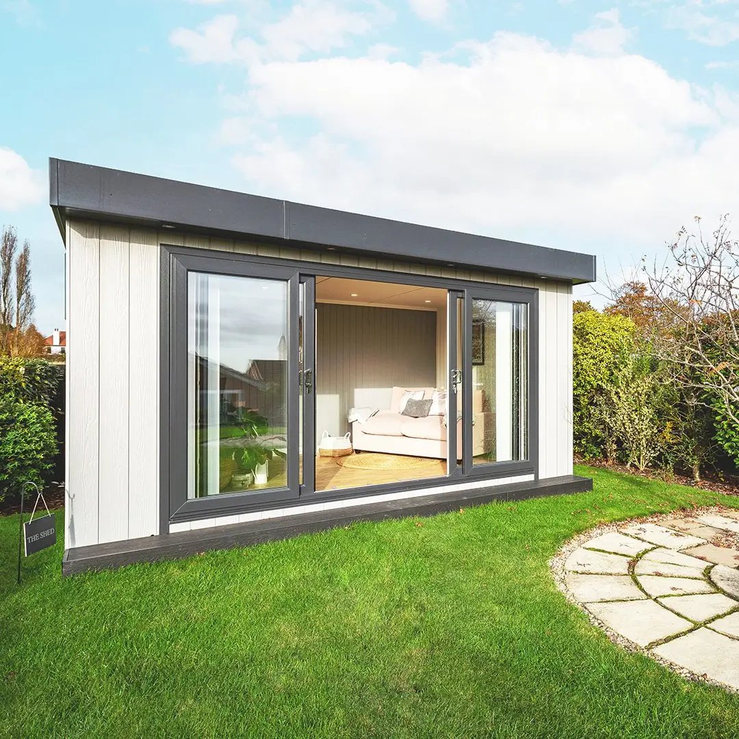 small marley board garden office with grassy lawn area and open sliding glass doors