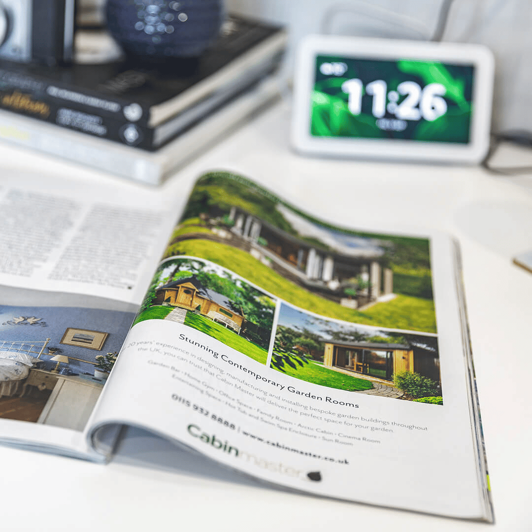 Magazine open at Cabin Master advert on desk