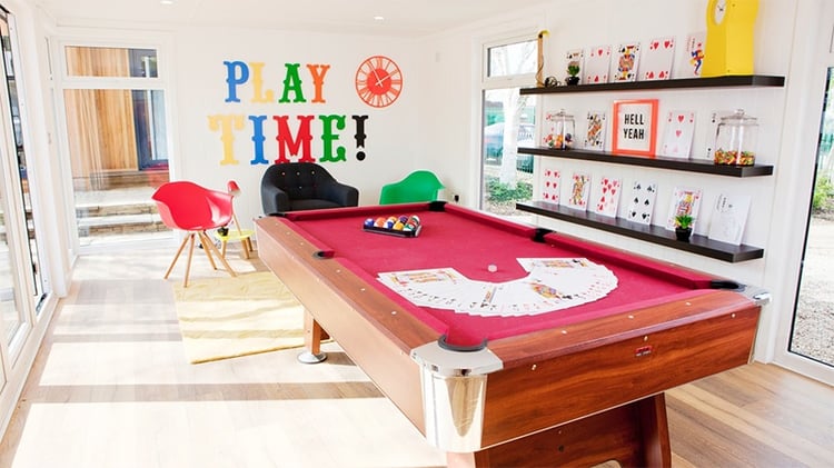Interior of a Garden Gaming Room eith red pool table and bright, fun decor