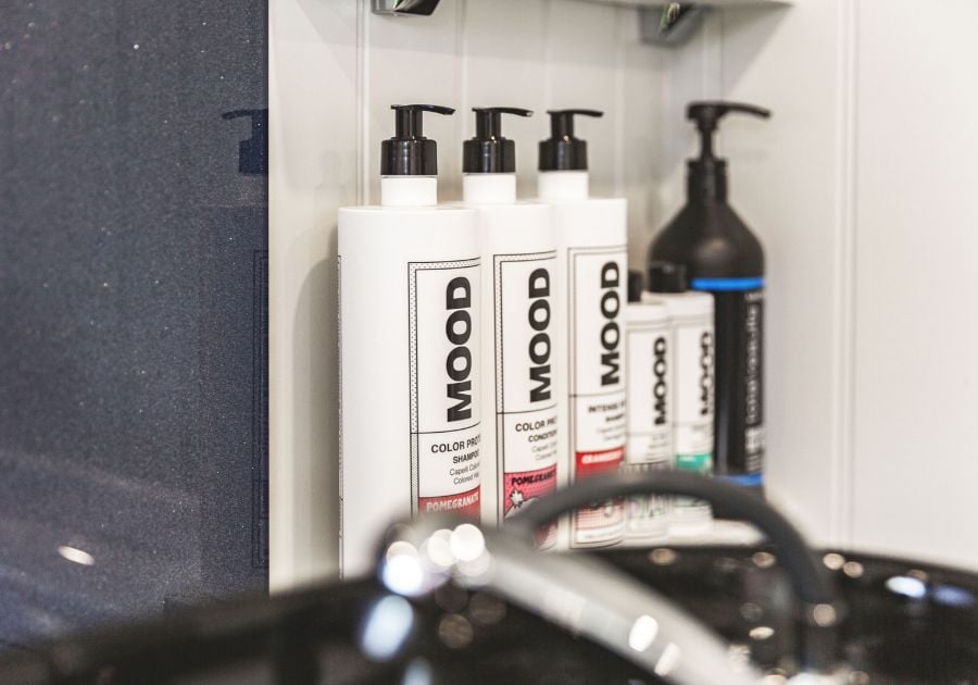 Professional MOOD haircare products displayed beside a black wash basin inside a bespoke garden hair salon.