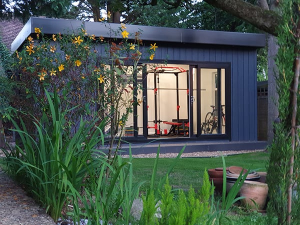Marley Board Gym Building in Garden with grassy area and trees in background and exercise equipment
