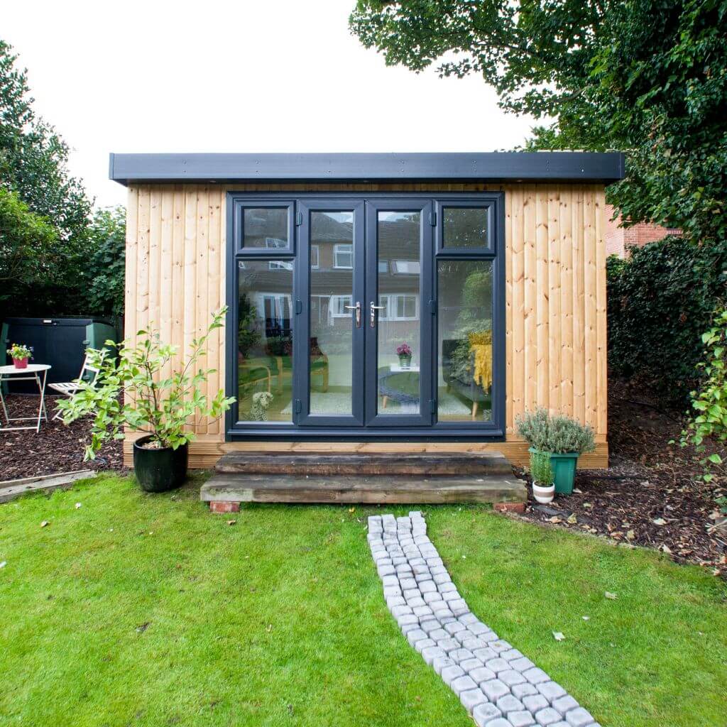 small garden pod building with lawn area and patio walkway with potted plant 