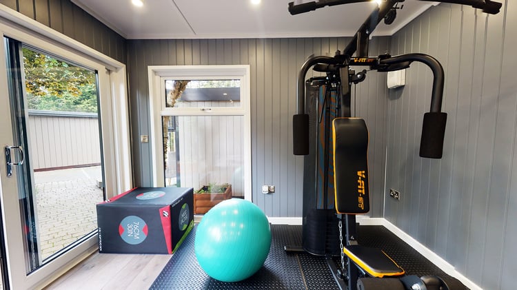 Inside a garden summerhouse gym room with exercise equipment
