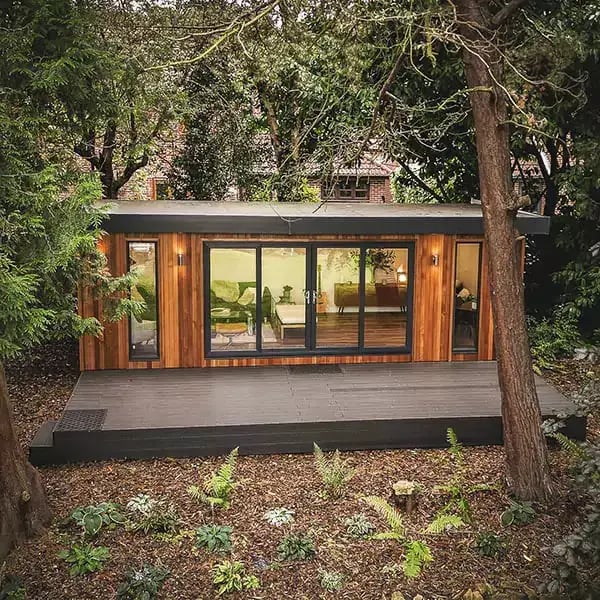 Timber large golf sim room in garden with decking