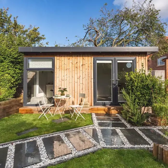 Timber large beauty spa room in garden with paving leading upto